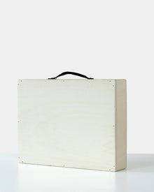 Minimalist wooden art crate with a black handle, closed and ready for safe artwork transportation or delivery.