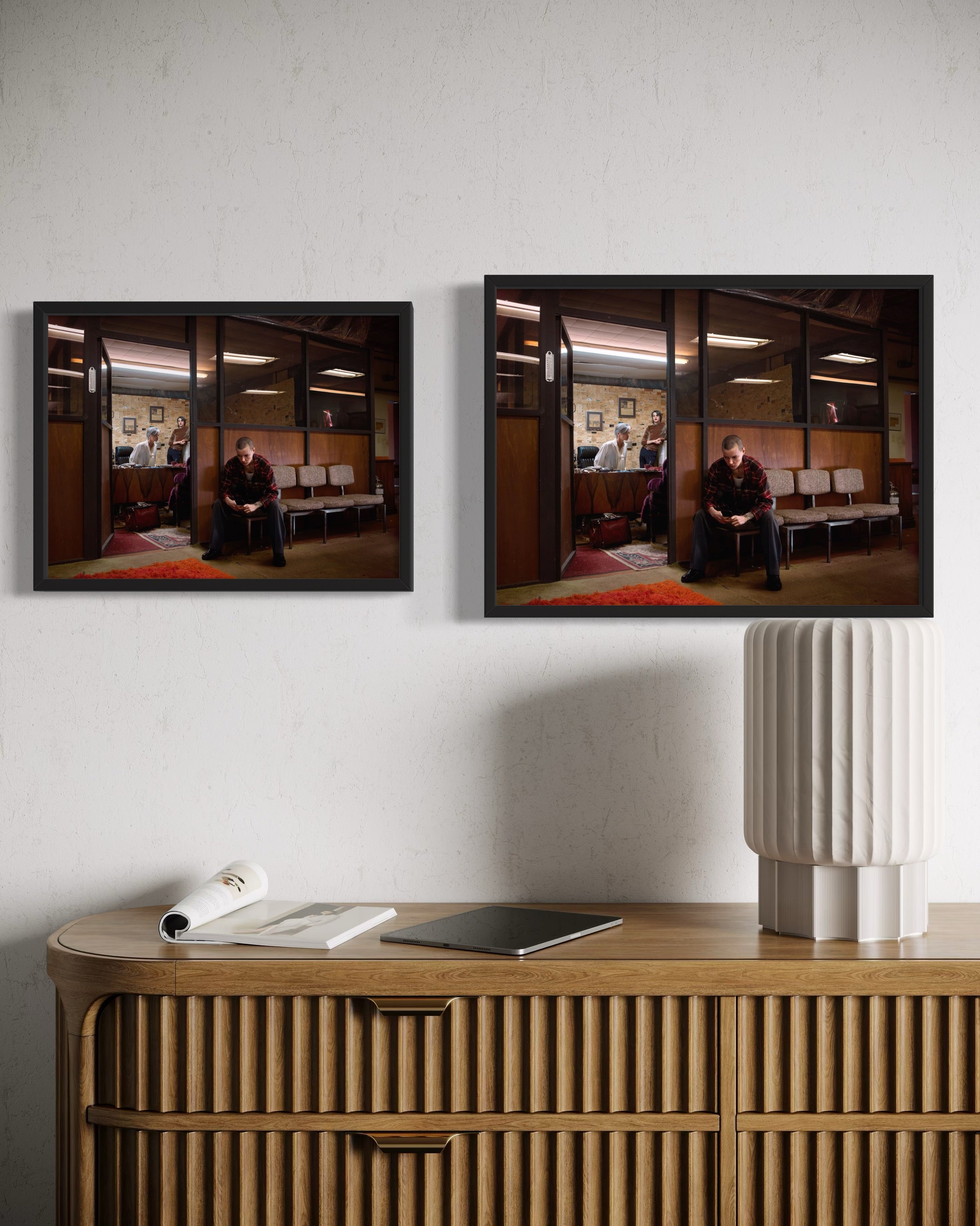 Two framed photographs on a wall above a wooden console table.