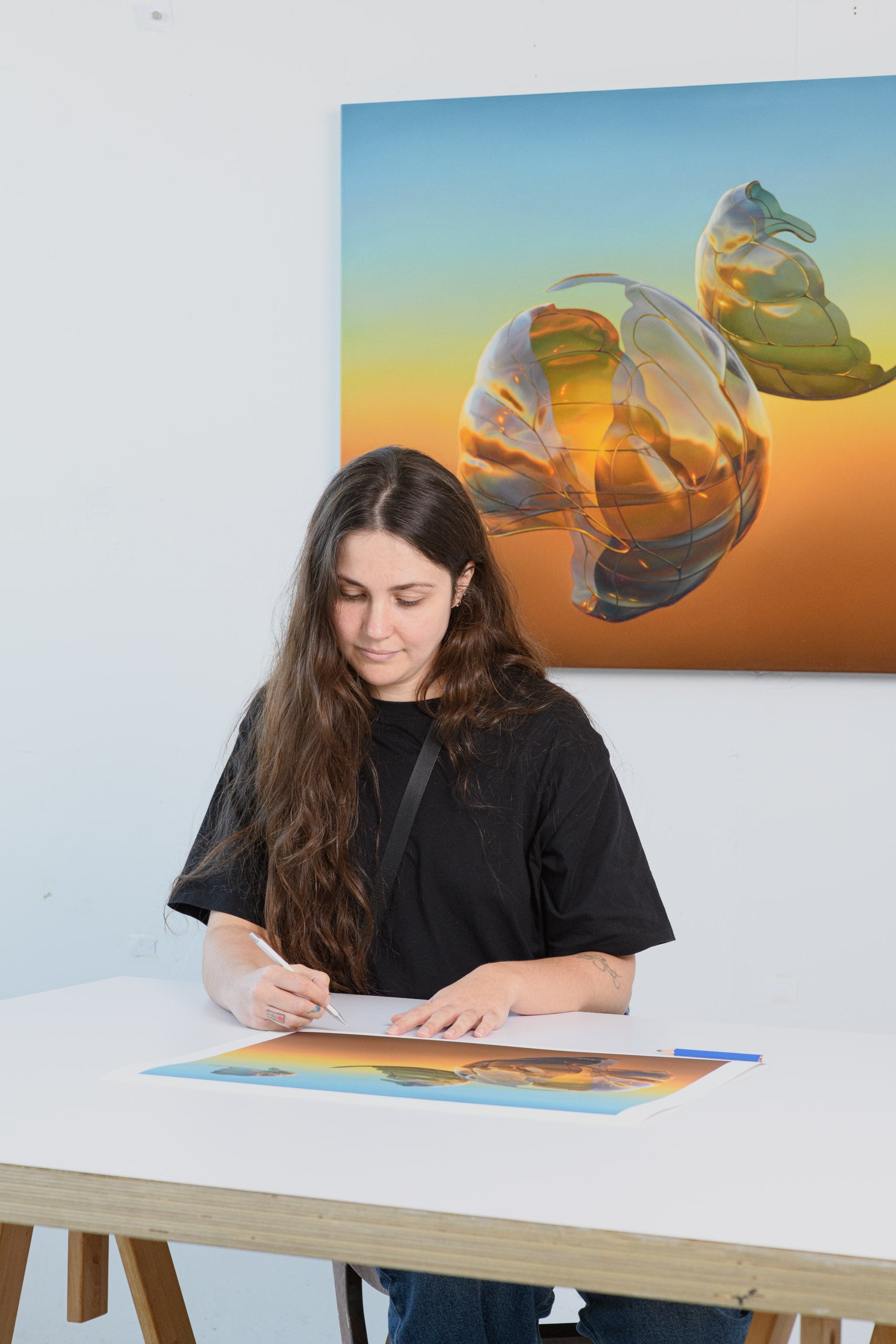 Woman sitting at a table with a colorful abstract painting on the wall behind her.